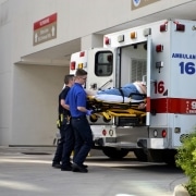 First responders lifting a stretcher into an ambulance