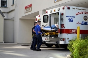 First responders lifting a stretcher into an ambulance