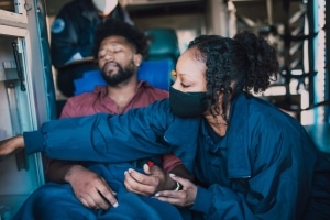 Female paramedic taking a man's vitals