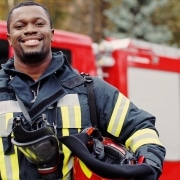 Smiling firefighter in front of a fire truck