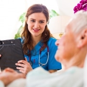 Healthcare professional speaking with an elderly patient