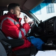 Male ambulance driver talking on the radio