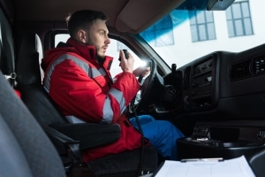 Male ambulance driver talking on the radio