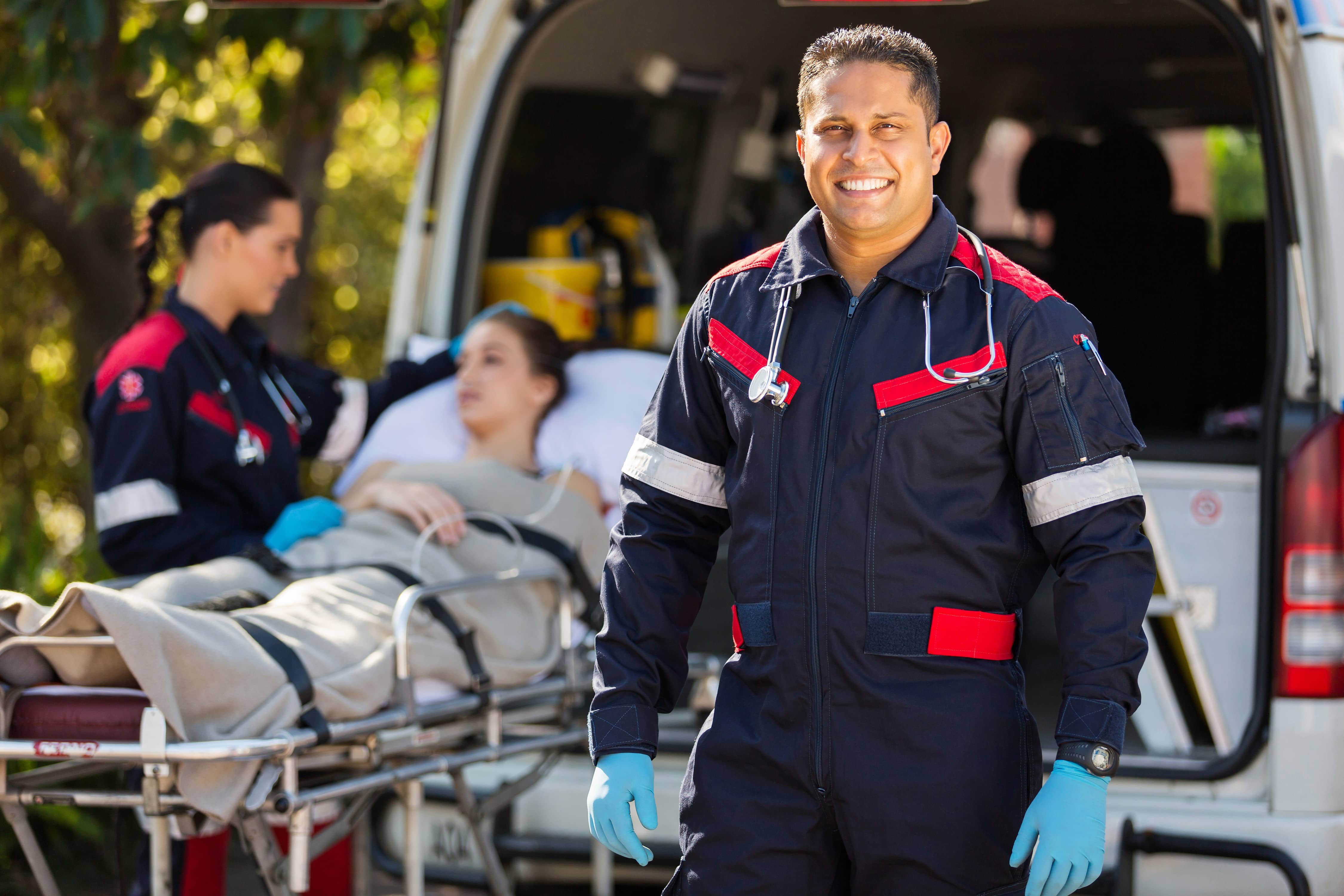 Smiling paramedic beside an ambulance