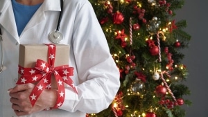 Medical professional in front of a Christmas tree