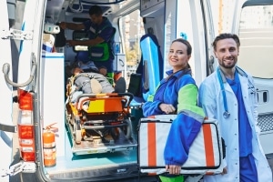 Medical workers standing beside an ambulance