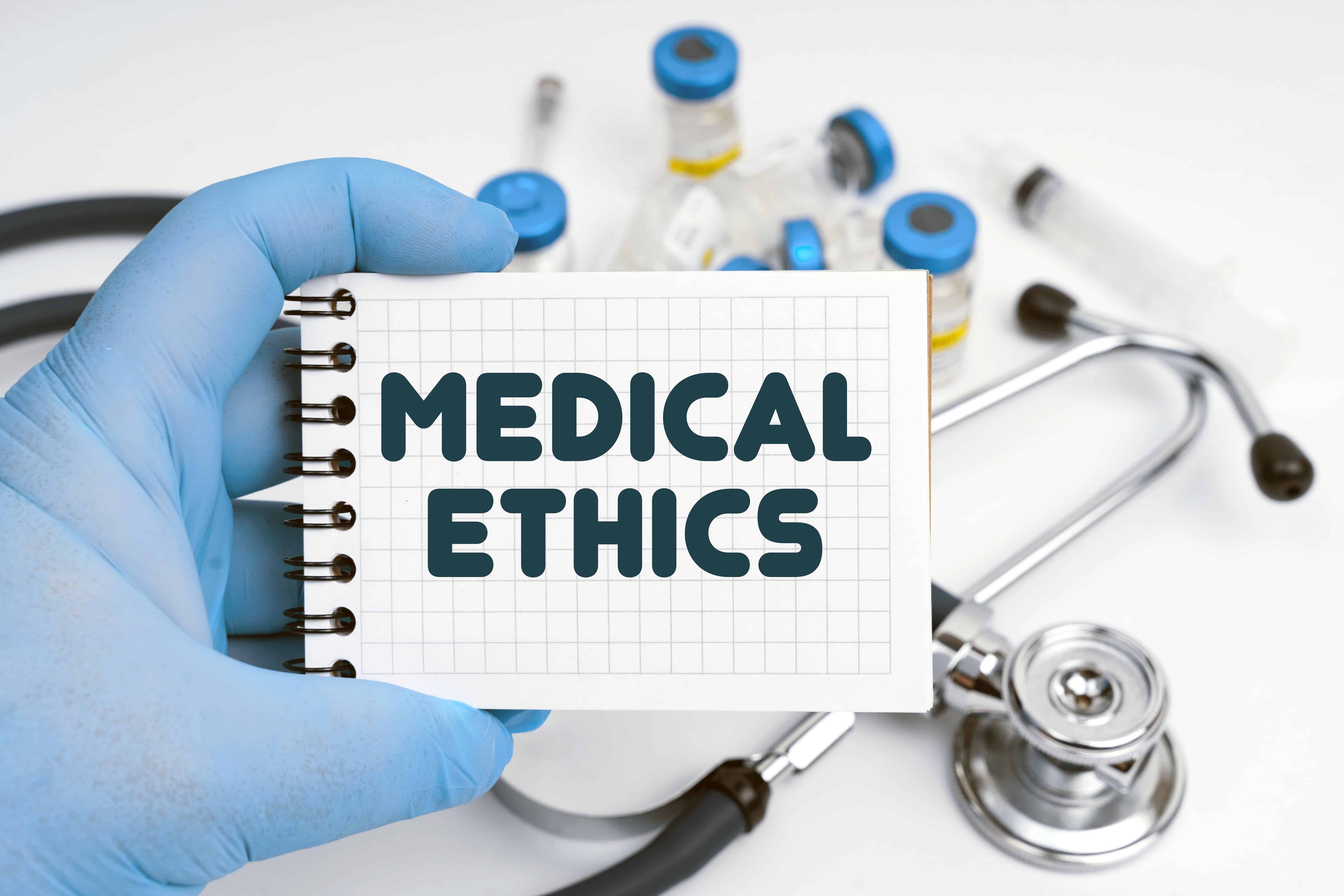 Gloved hand holding a medical ethics sign
