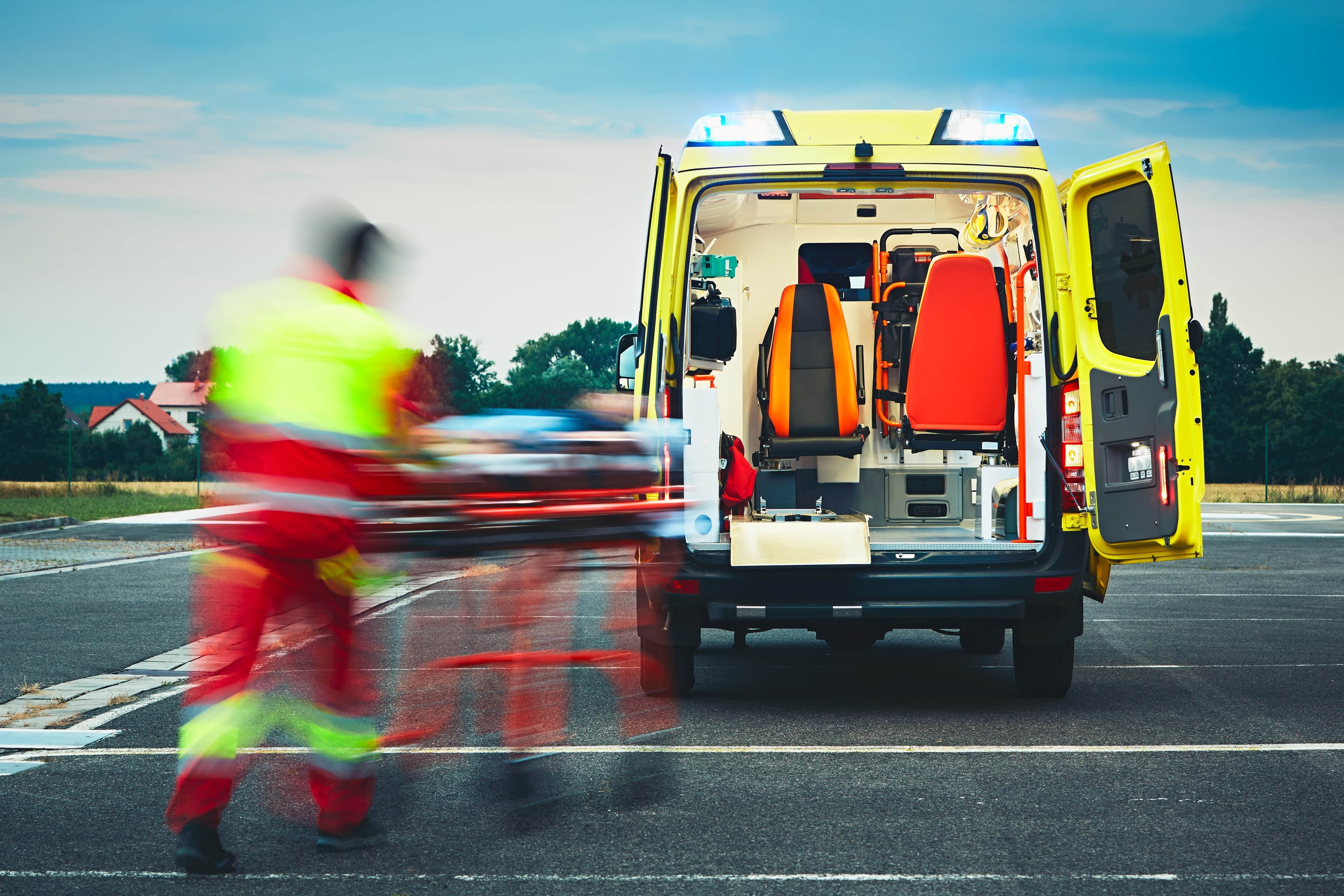 Blurred EMS professional transporting a patient to an ambulance