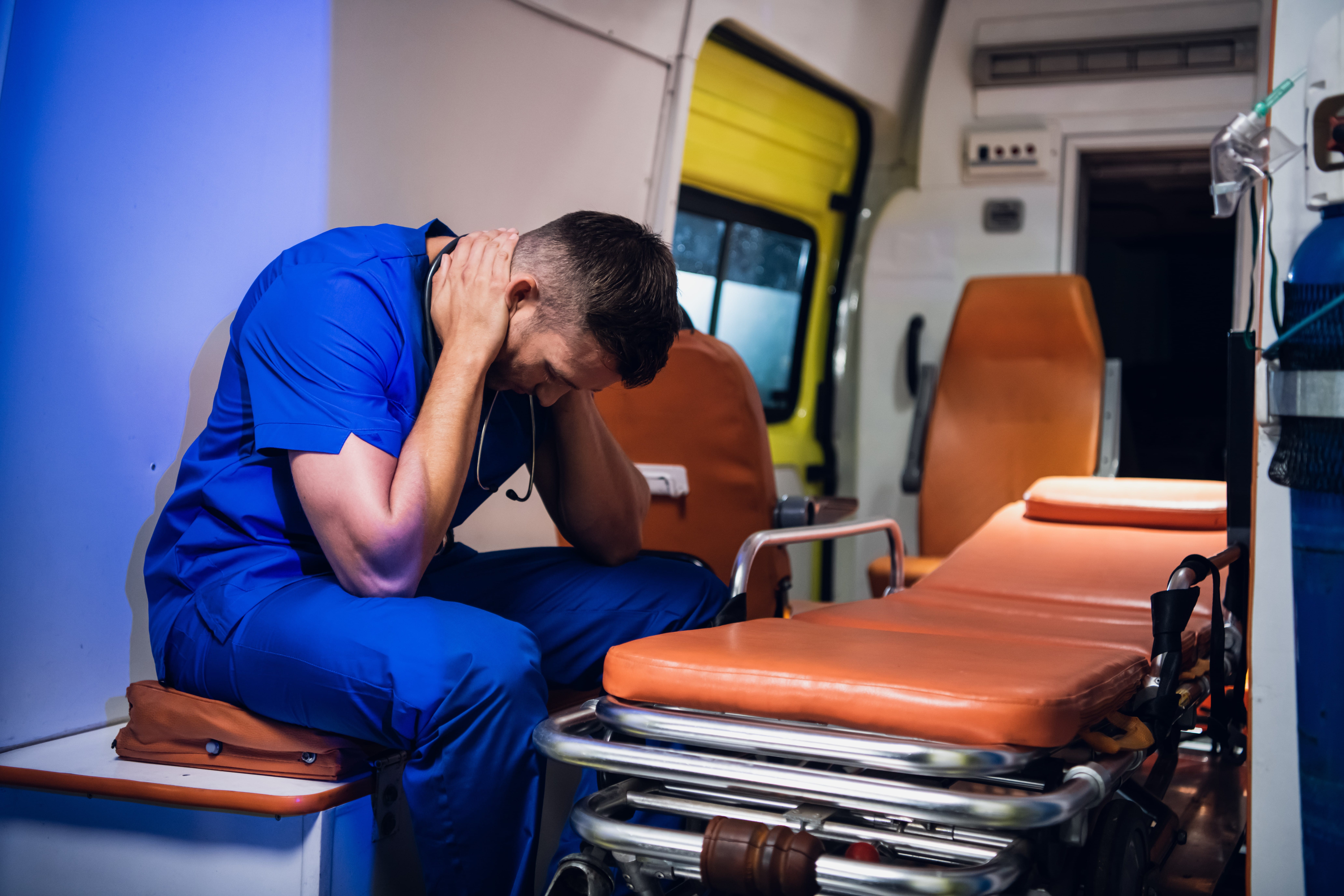 Male EMS professional with his head in his hands
