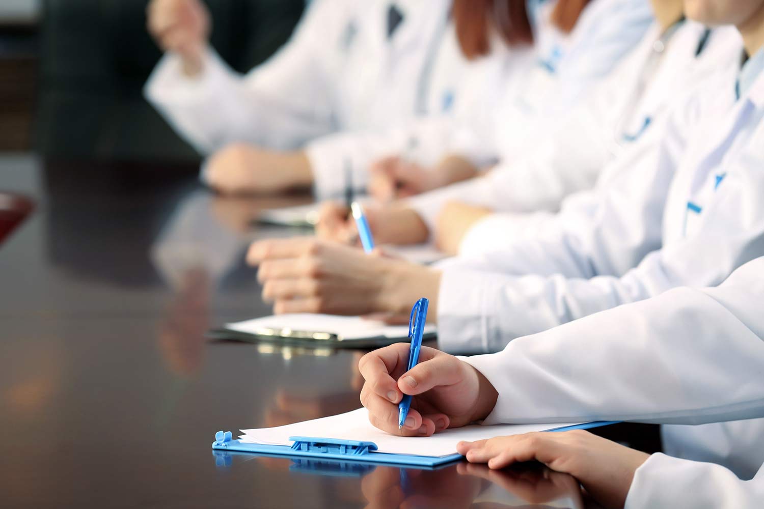 Close up of medical professionals taking notes